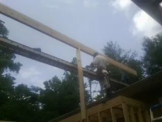Carpenter setting a ridge beam over a new addition frame — Ice Dam Removal by Roofing Brothers in Halfway