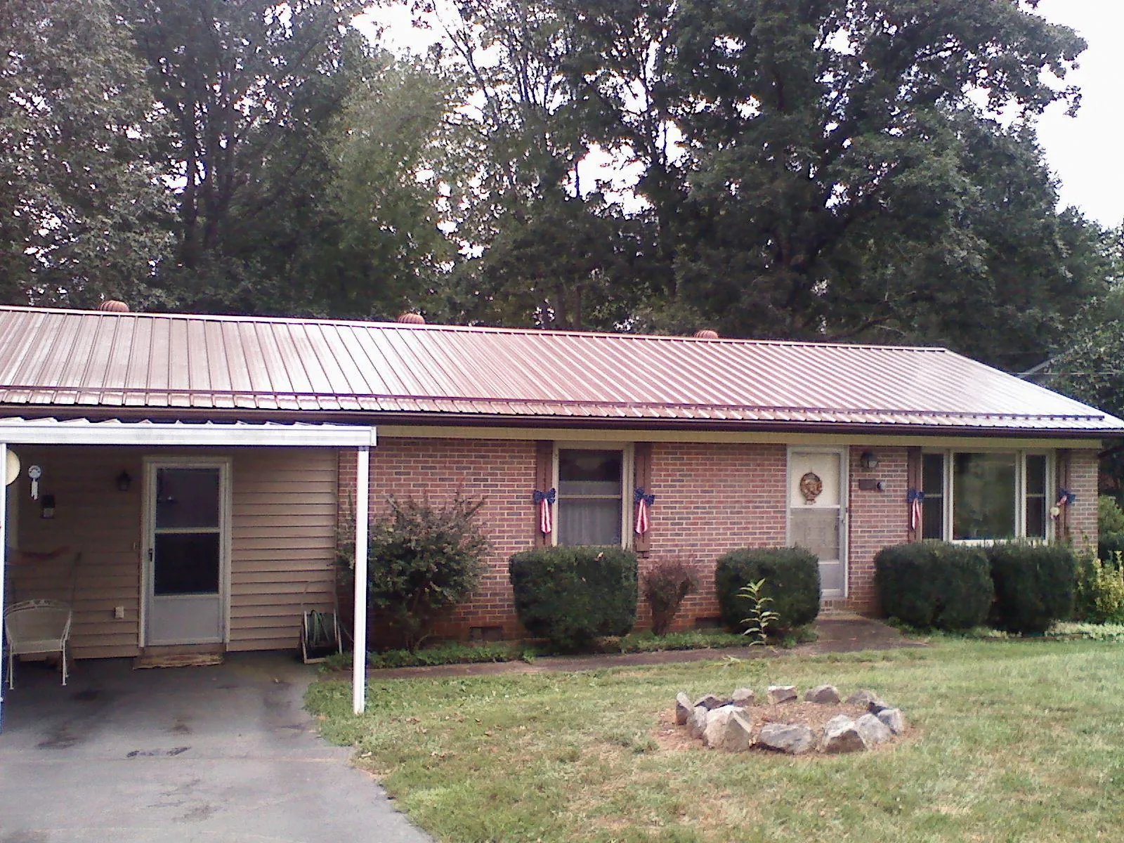 Bronze metal roof and carport on a brick ranch home — Roof Repair work by our crew in Halfway